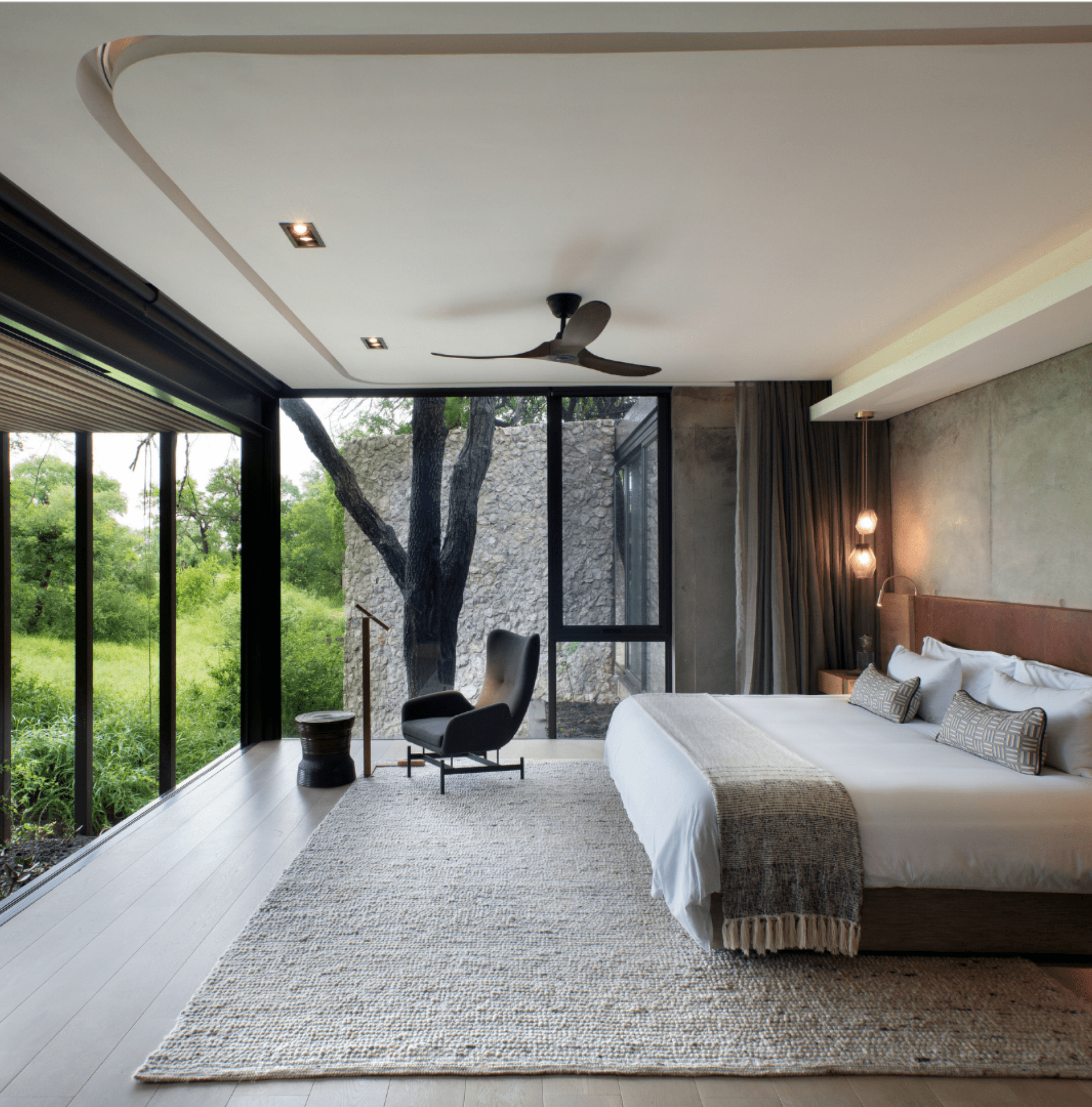 Luxurious room with glass walls overlooking safari bush