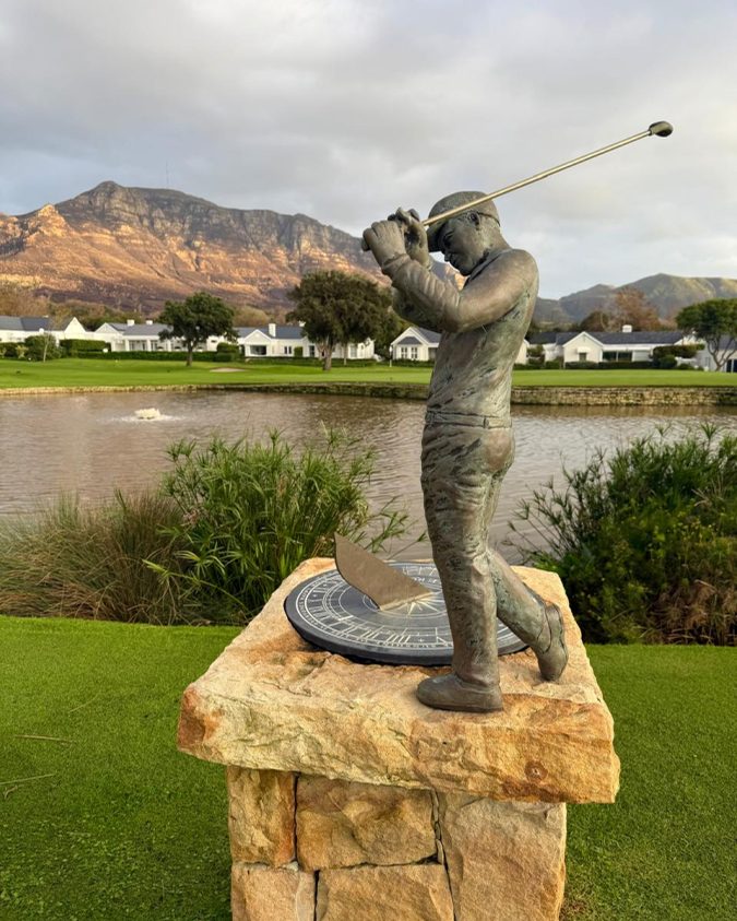 Bronze golfer statue on the Steenberg estate with the Constantia mountains behind