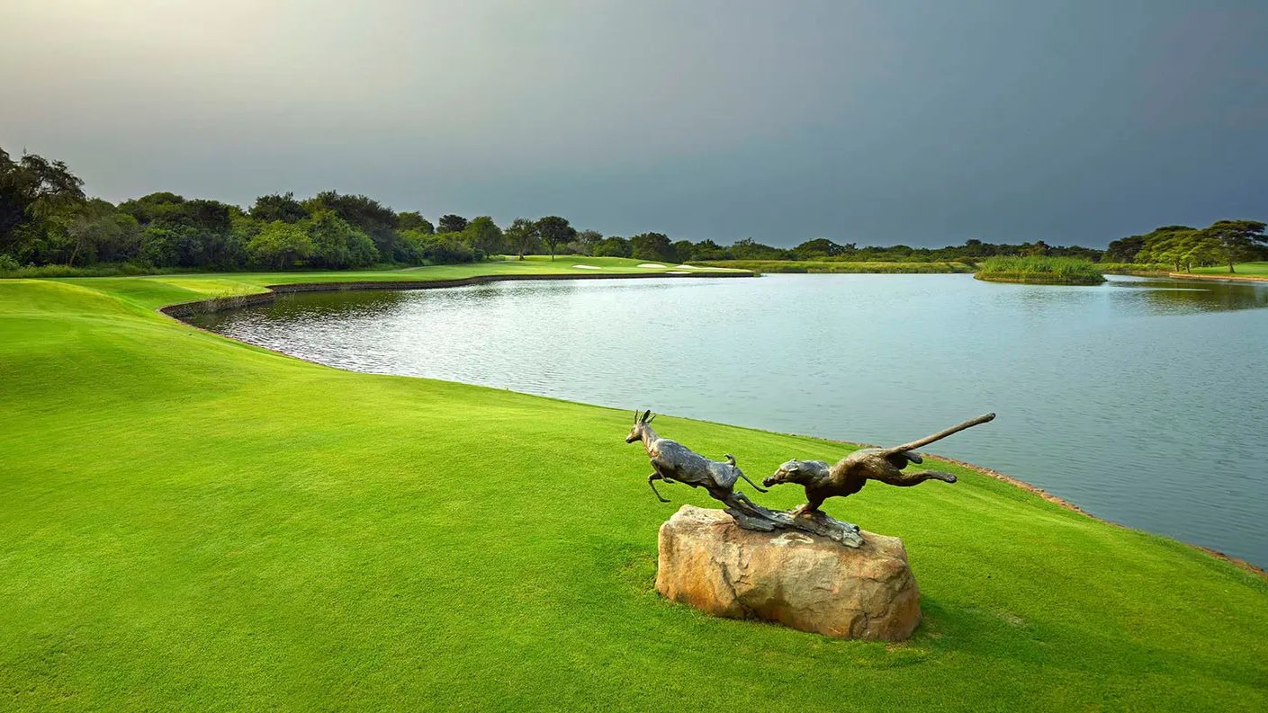 Bronze wildlife sculpture beside the water on a green at Leopard Creek Country Club