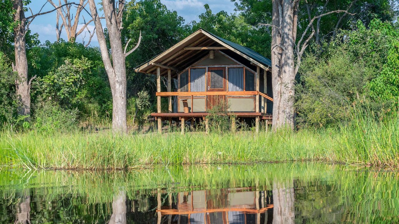 Raised tented suite at Saguni Safari Lodge reflected in the Sable River