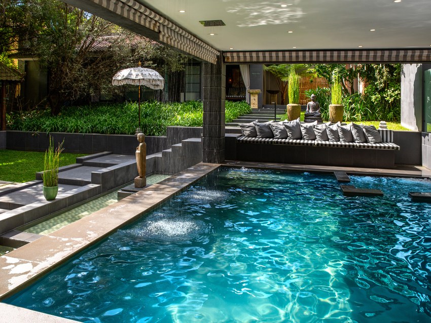 The swimming pool at Fairlawns, set among bamboo and planting with loungers along one side