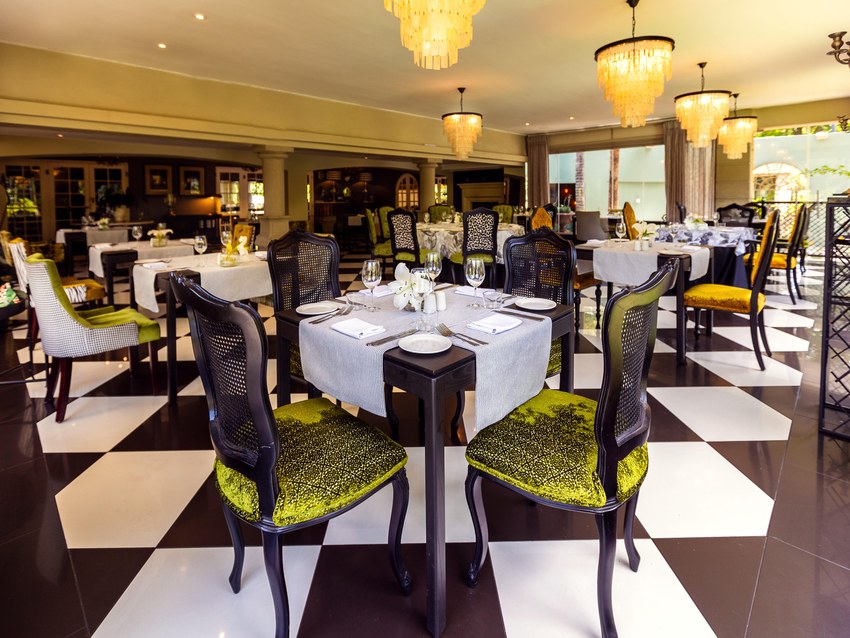 The restaurant at Fairlawns with a black and white chequered floor and green upholstered chairs
