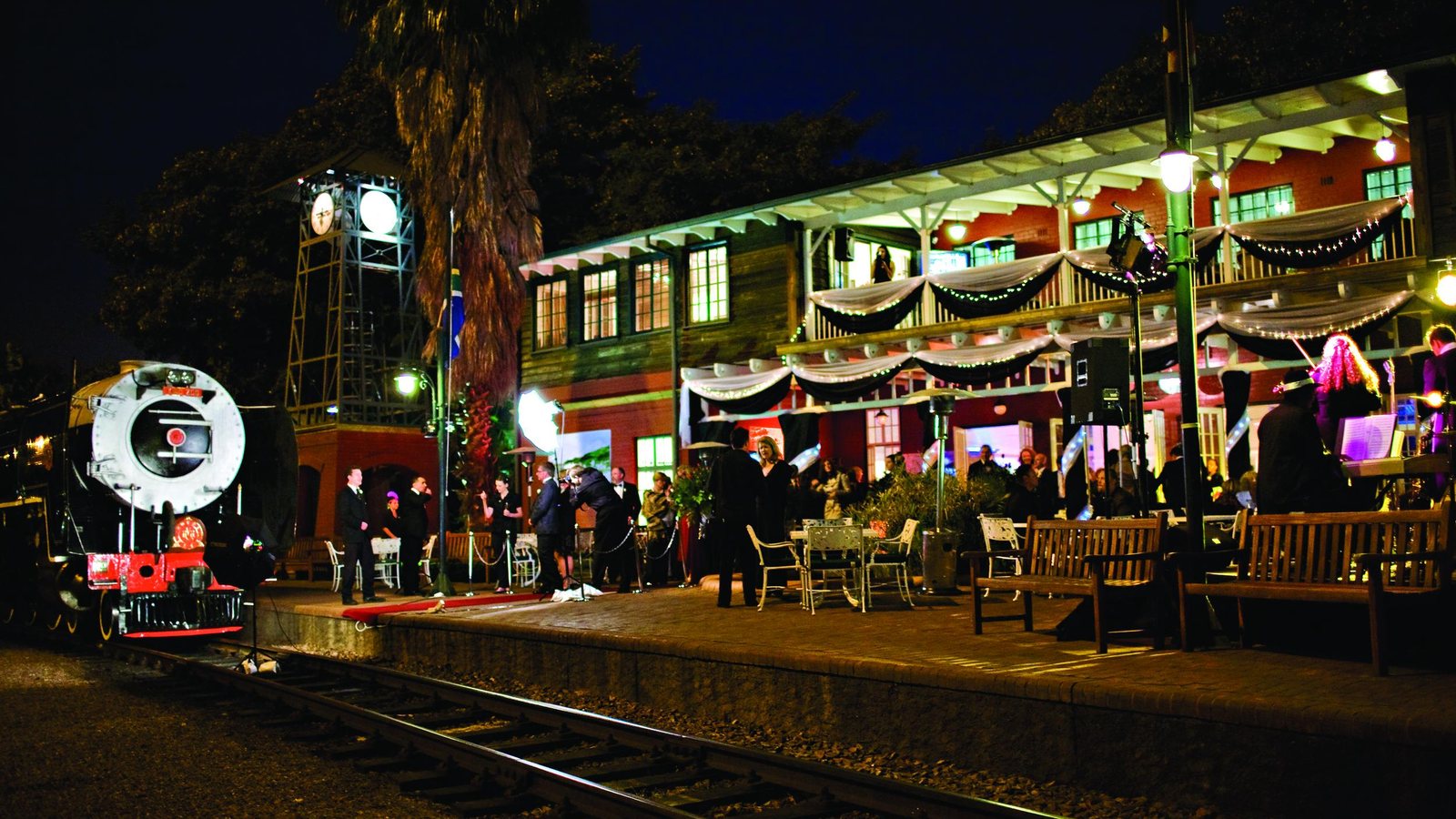 The Rovos Rail train lit at night on the platform at Capital Park station, Pretoria, with guests gathered before departure