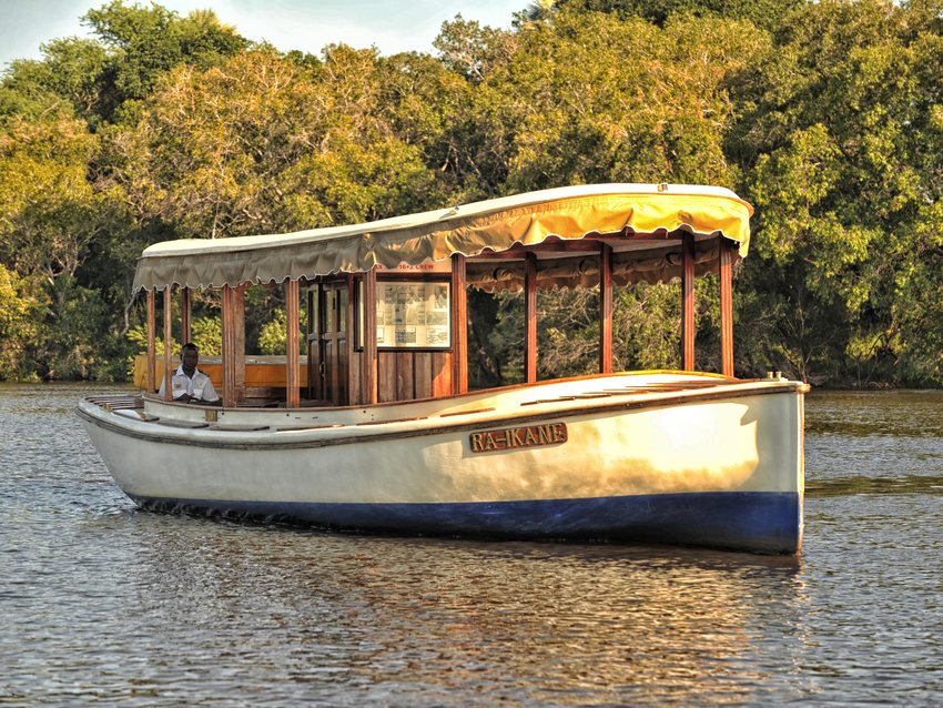 A classic wooden river boat on the Zambezi at golden hour