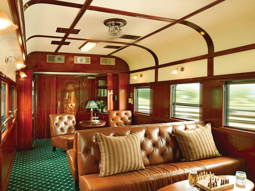 The lounge car aboard Rovos Rail with a leather chesterfield sofa, lamps and a chess set