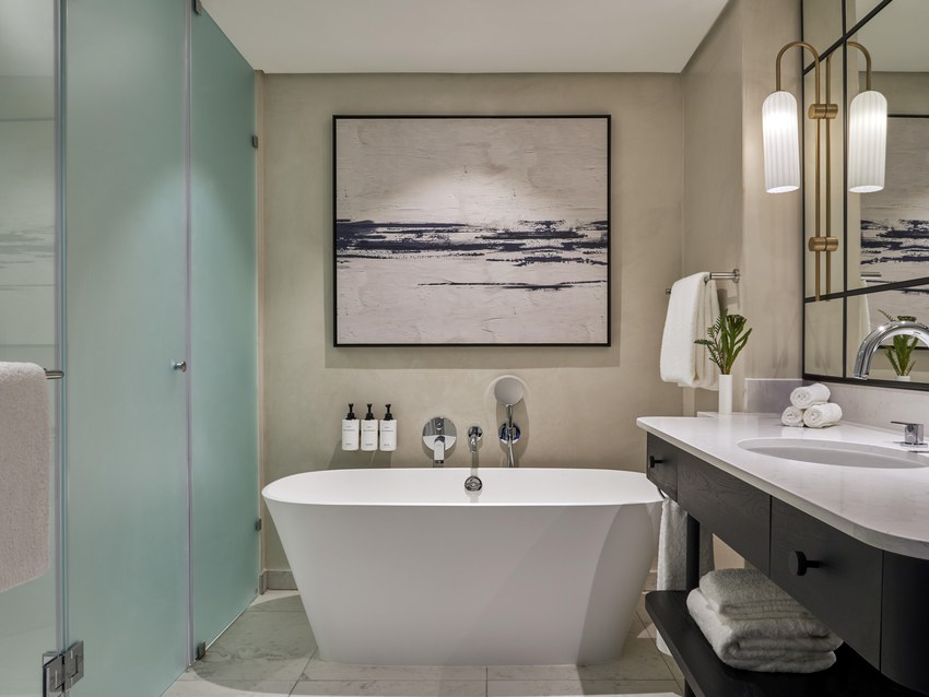A bathroom at the InterContinental Table Bay with a freestanding bath, twin basins and a walk-in shower