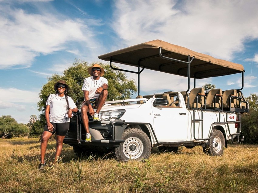 Two guides beside an open game-viewing vehicle used for the Chobe day trip from Victoria Falls