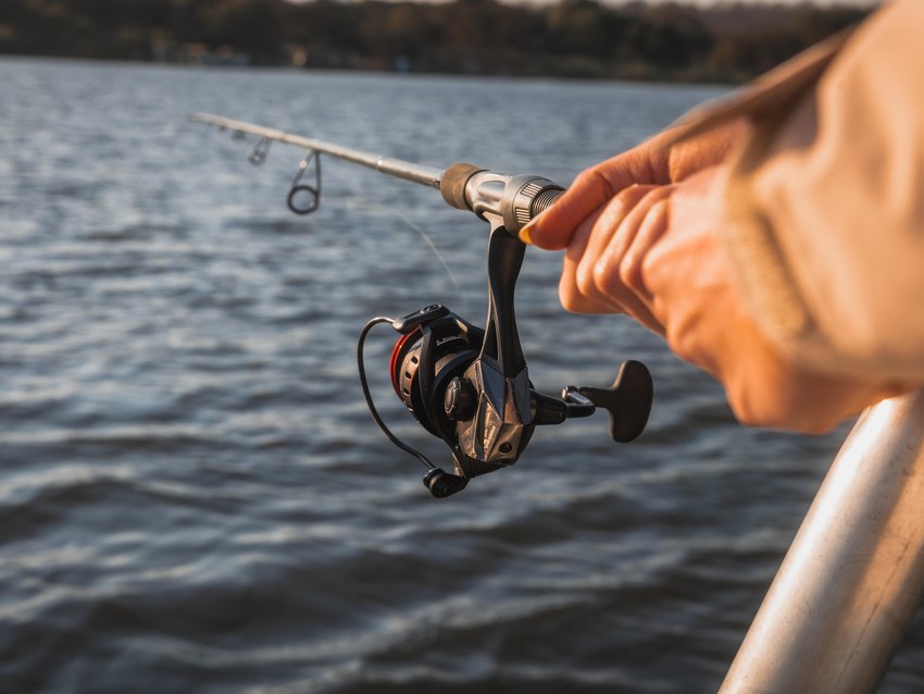 A guest fishing with a spinning reel from a boat on the Chobe River