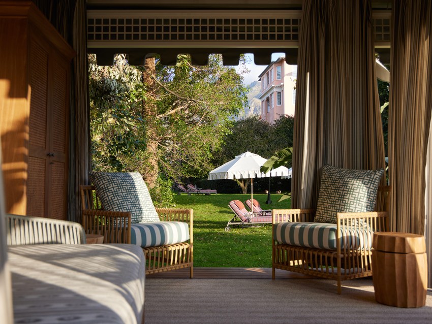A suite living area at the Mount Nelson looking through tall windows onto the hotel gardens
