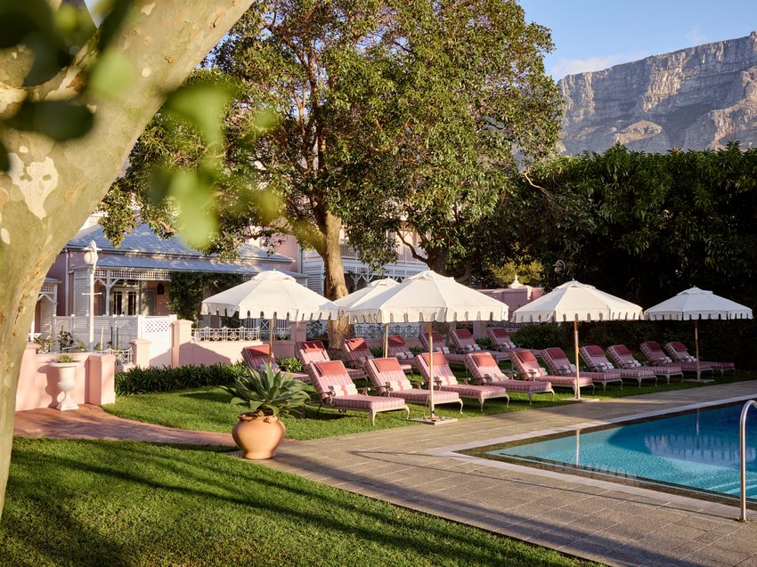 The heated pool at the Mount Nelson surrounded by loungers, gardens and Table Mountain beyond