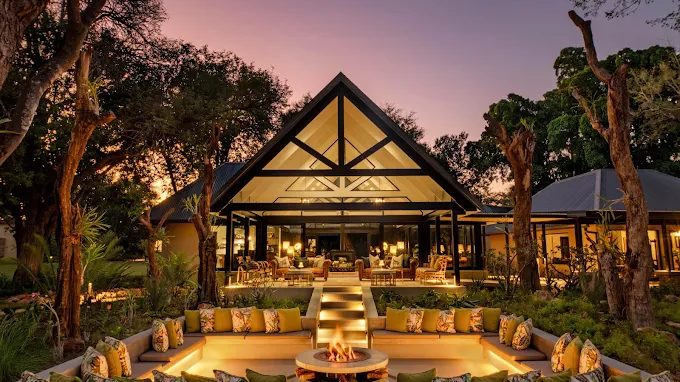 Kings Camp main lodge and boma fire pit lit at dusk, Timbavati