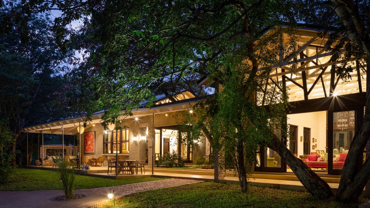 Mbano Manor Hotel lit at dusk in the Victoria Falls rainforest